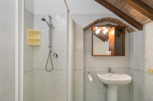 y baño con ducha y lavamanos. en Il Pino - appartamento Alloro, en Cecina