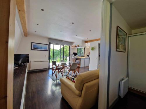 a living room with a couch and a dining room at Hameau de la Brelaudière in Jullouville-les-Pins