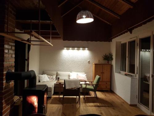 ein Wohnzimmer mit einem Sofa und einem Tisch mit Stühlen in der Unterkunft Rustical cottage with indoor fireplace in Sodražica