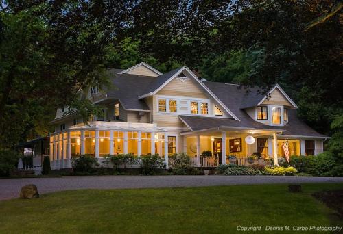 a large house with lights on in a yard at Copper Beech Inn in Ivoryton