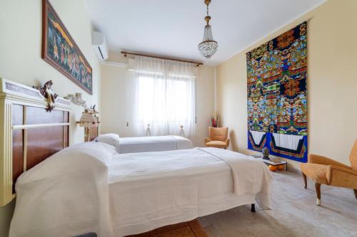 sypialnia z dużym białym łóżkiem i obrazem na ścianie w obiekcie Art Beds & Garden 9 beds between the sea, thermal baths, and the Tuscan countryside w mieście Suvereto
