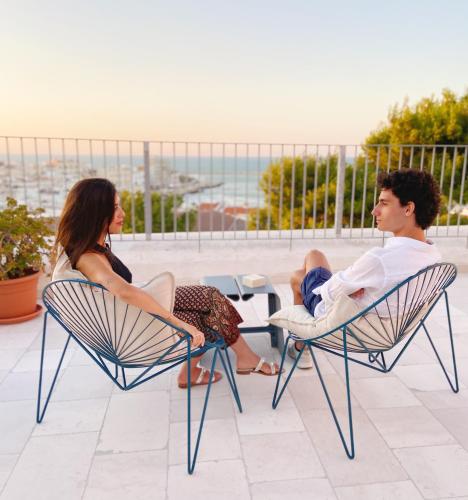 a man and a woman sitting in chairs on a patio at Dimora Cummà Marì in Vieste