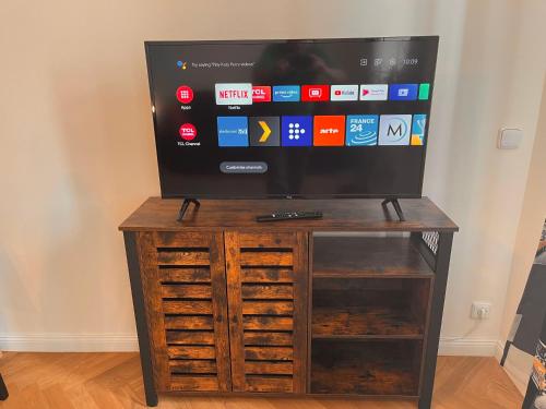 a television on top of a wooden entertainment center at Riverbridge Apartments Prague in Prague