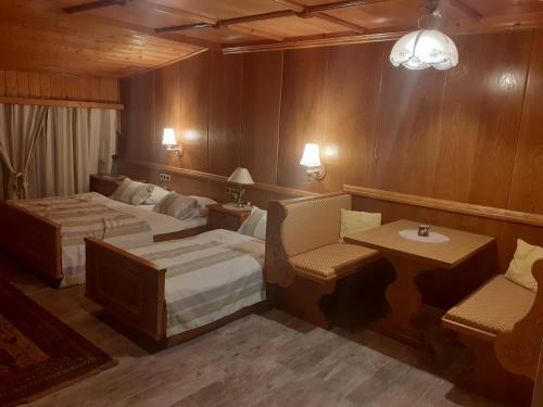 a bedroom with two beds and a table and chairs at Kupreski san1 in Kupres