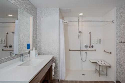 La salle de bains blanche est pourvue d'un lavabo et d'une douche. dans l'établissement Home2 Suites By Hilton Vero Beach I-95, à West Vero Corridor