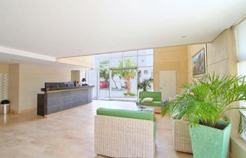 an office lobby with plants and a counter at Apartamentos Velas al Mar Rodadero in Puerto de Gaira