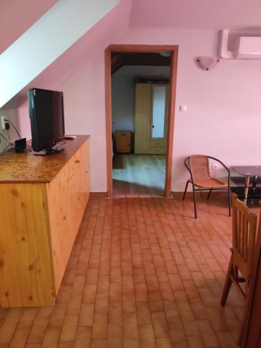 a living room with a tv and a table and chairs at Katica Vendégház in Siófok