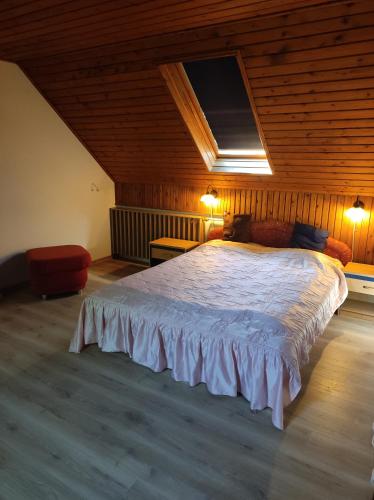 a bedroom with a large bed in a attic at Katica Vendégház in Siófok