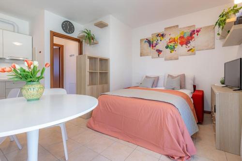 una camera con letto e tavolo bianco di Studio with garden and parking, near Como Lake ad Albese Con Cassano