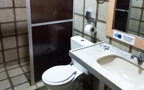 a bathroom with a toilet and a sink at Pousada Casa Grande in Bonito