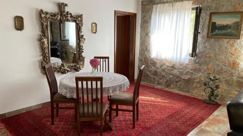 a dining room with a table and chairs and a mirror at House in the Mountains near Budva in Budva