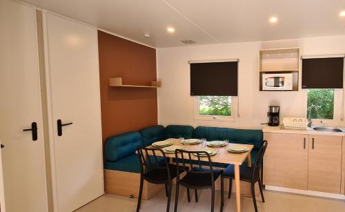 - une cuisine et une salle à manger avec une table et un canapé dans l'établissement Camping Domaine Papillon, à Reyrevignes