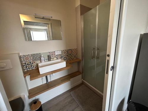 y baño con lavabo y ducha. en Appartement pour évasion marine à Hauteville sur mer en Hauteville-sur-Mer