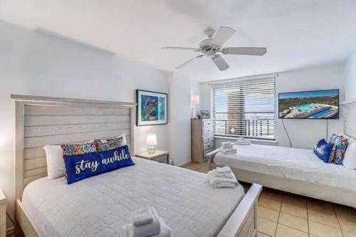 a bedroom with two beds and a ceiling fan at Relax with a Fabulous Ocean View Ocean Sounds in This 2 Bedroom 2 Bath Den in Port Aransas