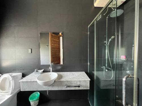 a bathroom with a sink and a shower at Nancy Tran Grand Strip Vung Tau Villa 8 in Vung Tau