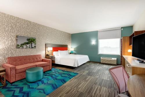 a hotel room with a bed and a couch at Home2 Suites By Hilton Vero Beach I-95 in West Vero Corridor