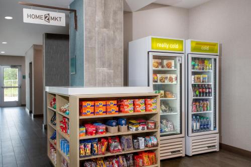 a store aisle with two refrigerators and food at Home2 Suites By Hilton Vero Beach I-95 in West Vero Corridor