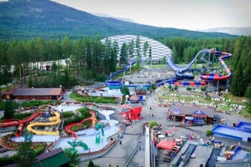 un parc d'attractions avec des montagnes russes et des toboggans dans l'établissement Lys og moderne leilighet i Bø., 