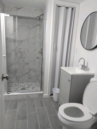 a white bathroom with a toilet and a shower at Dupont Beach House A in Seaside Heights