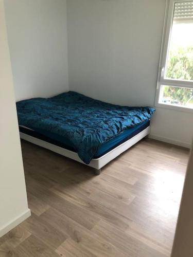uma cama num quarto com piso em madeira em Logement neuf proche plage et aéroport em Nice