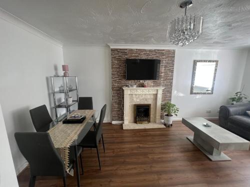 a living room with a table and a fireplace at Corby Guest House in Corby