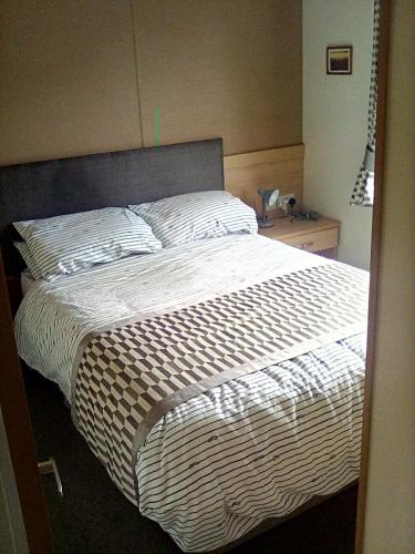 a bedroom with a large bed with a white comforter at LakeView Lodge Trevella Park in Crantock