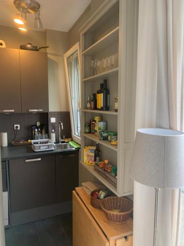 eine Küche mit einer Theke und einem Tisch mit einer Lampe in der Unterkunft Porte Maillot-Charming and calm studio at Neuilly in Neuilly-sur-Seine
