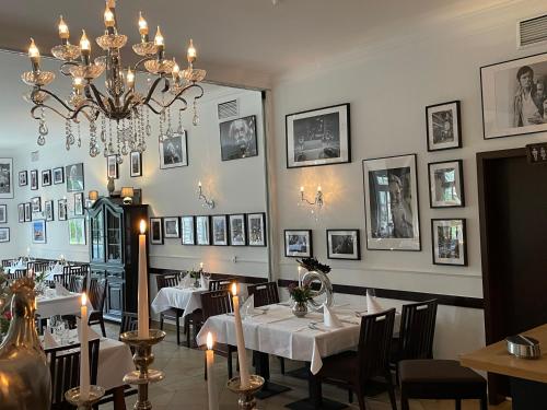 a dining room with two tables and a chandelier at dS Hotel Gronau in Gronau