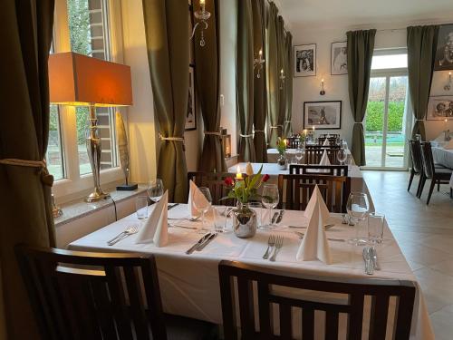 a dining room with two tables with white tablecloths at dS Hotel Gronau in Gronau