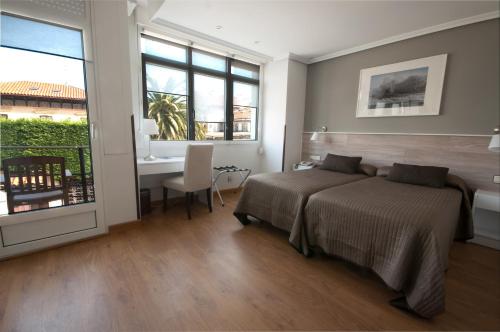 リバデセリャにあるHotel Don Pepe Riaのベッドとテーブルと机のある寝室
