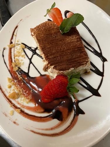 a plate with a piece of cake with chocolate and strawberries at dS Hotel Gronau in Gronau
