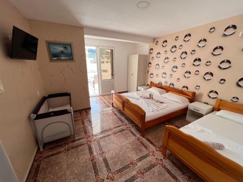 烏爾齊尼的住宿－Peci Apartments，一间带两张床的卧室和一台电视