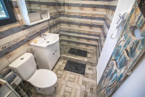 a bathroom with a toilet and a sink at Flip Flop Bungalows in Vadu