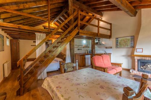 una sala de estar con una escalera de madera y una mesa en Apartamentos Rurales Los Picos de Redo en Camaleño