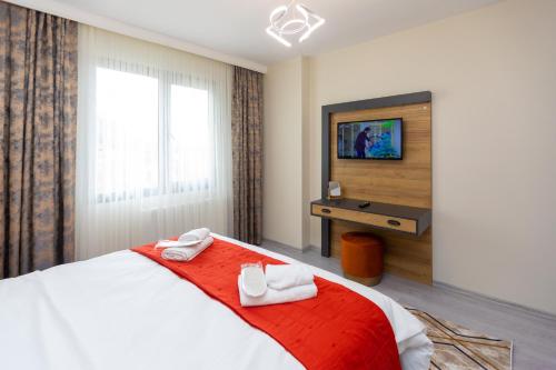 1 dormitorio con 1 cama con 2 toallas en Moonlight Suite Hotel, en Trabzon