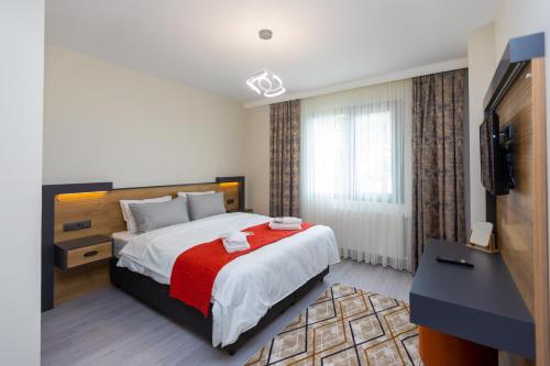 Moonlight Suite Hotel في طرابزون: غرفة نوم بسرير كبير مع بطانية حمراء