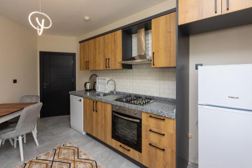 - une cuisine avec des placards en bois et un réfrigérateur blanc dans l'établissement Moonlight Suite Hotel, à Trabzon
