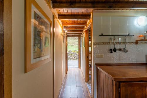 a kitchen with a counter top and a hallway at Apartamentos Rurales Los Picos de Redo in Camaleño