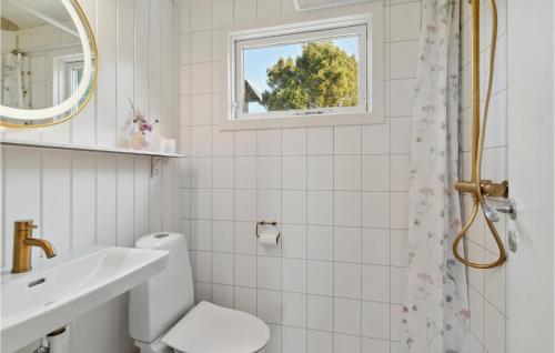 uma casa de banho com um WC, um lavatório e uma janela em Stunning Home In Knebel With House Sea View em Ørby