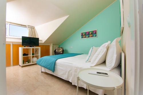 1 dormitorio con 1 cama con mesa y TV en Prime blue suite - Giardini en Riccione