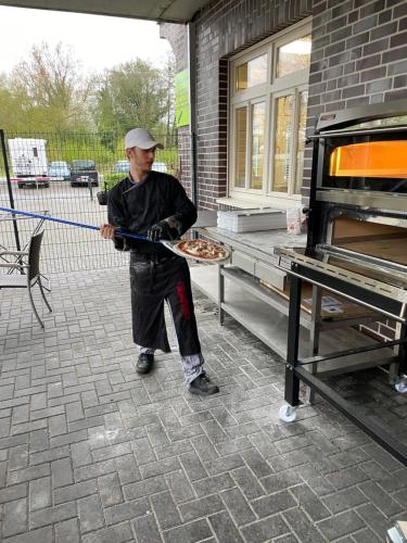 a man holding a blue rope in front of an oven at dS Hotel Gronau in Gronau