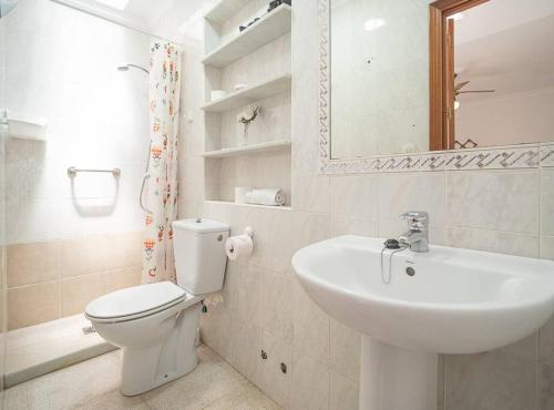 y baño con aseo, lavabo y espejo. en SibsSanlucar Albero - Ideal Familias - Centro - Playa Piletas, en Sanlúcar de Barrameda