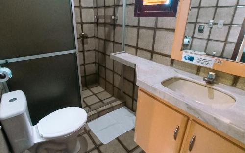a bathroom with a toilet and a sink at Pousada Casa Grande in Bonito