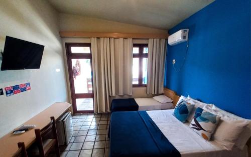 a bedroom with two beds and a blue wall at Pousada Casa Grande in Bonito