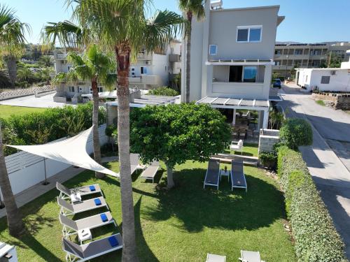 an aerial view of a resort with lounge chairs and palm trees at Sea La Vie in Adelianos Kampos