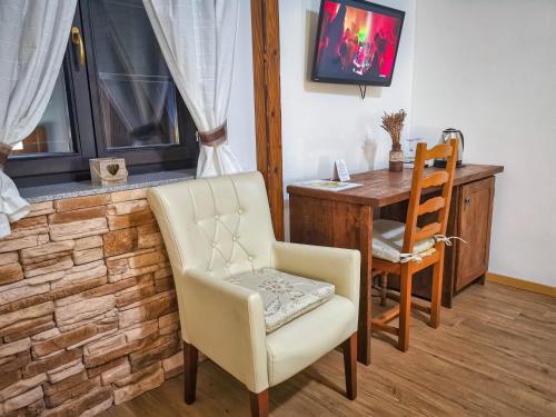 Habitación con escritorio, silla y mesa. en Etno Garden Exclusive Rooms, en Plitvica Selo