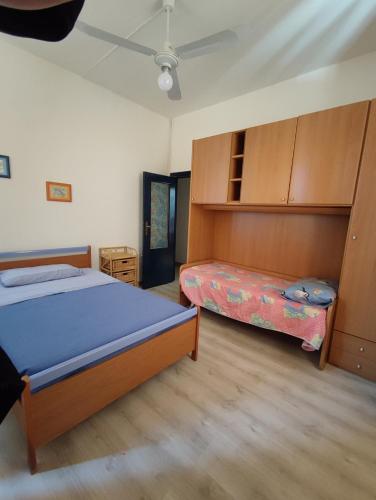 - une chambre avec 2 lits et des placards en bois dans l'établissement Affreschi & Trabocchi House, à Treglio