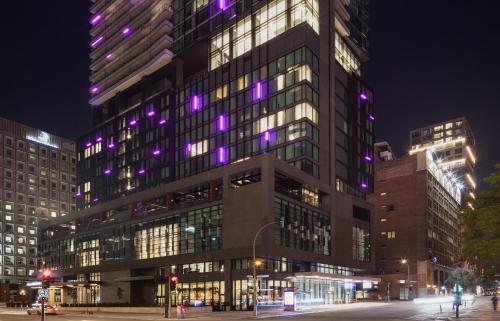a tall building with purple lights on it at HONEYROSE Hotel, Montreal, a Tribute Portfolio Hotel in Montréal