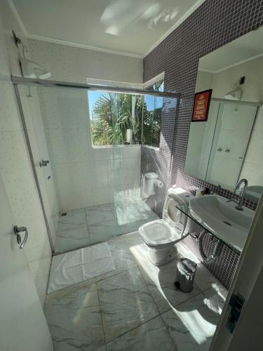 a bathroom with a shower and a toilet and a sink at Albergo Alegria in Nova Lima