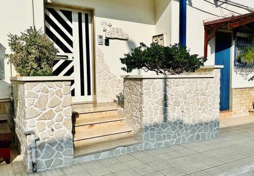 uma casa com dois vasos de plantas na porta da frente em FAR WEST em Ginosa